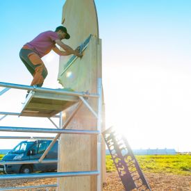 Juhlaportin viimeistely käynnissä. Porttiin asennetaan seurojen tunnus "Herra siunatkoon sinua".