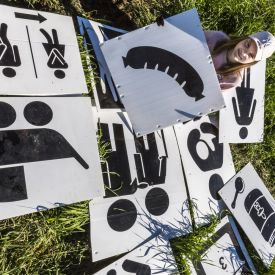 Miira Määttä opaskylttien lajittelutyössä. Näiden kylttien tulkitseminen ei vaadi kielitaitoa.