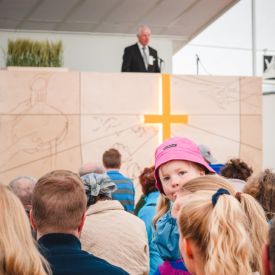 Aini kuunteli seurapuhetta äitinsä sylissä.